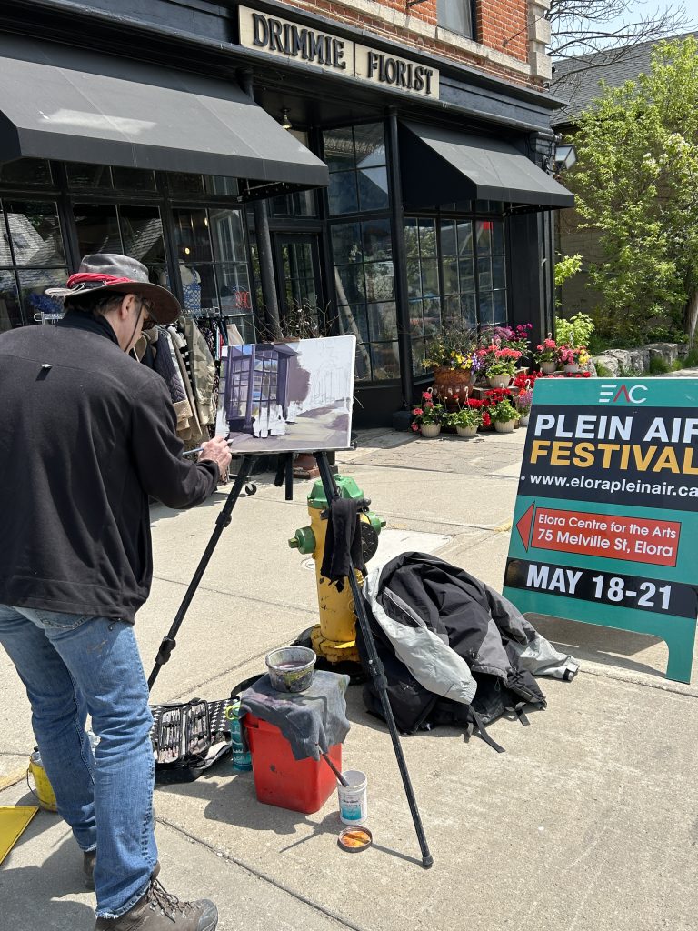 Artist Greg Hargarten paints Drimmie Florists on Geddes Street in downtown Elora during the Elora Plein Air Festival. He was one of more than 90 artists who converge on Elora and Fergus for the May long weekend for the annual Elora Plein Air Festival.
